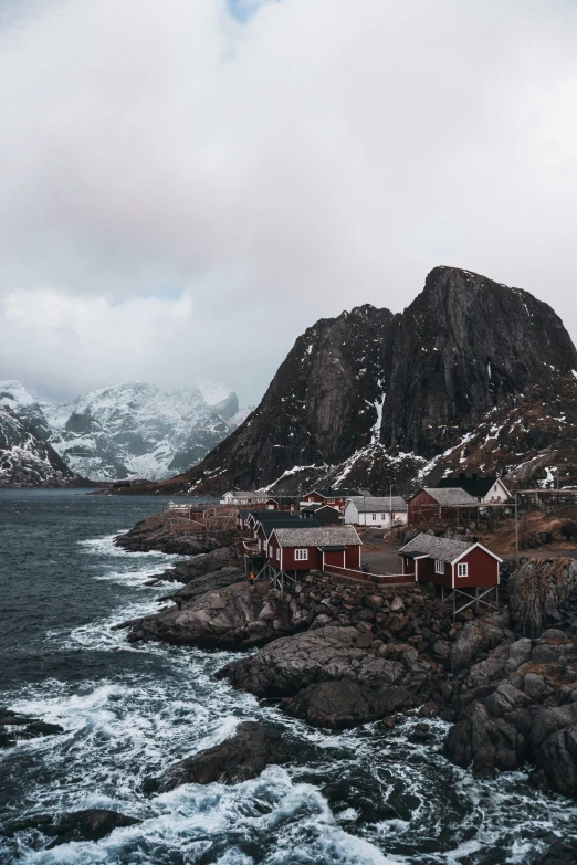 a small house sitting on top of a small cliff next to the ocean