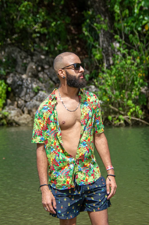 a bald man wearing shorts standing in the water