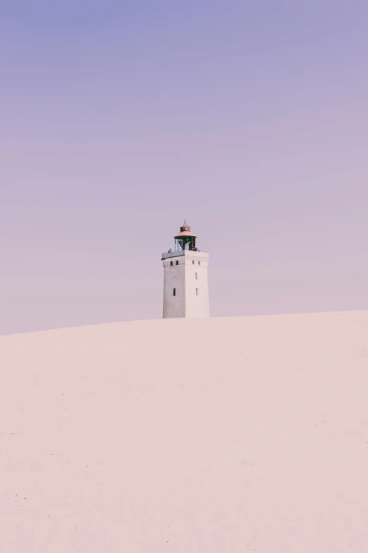 a lighthouse sitting on the top of a desert hill