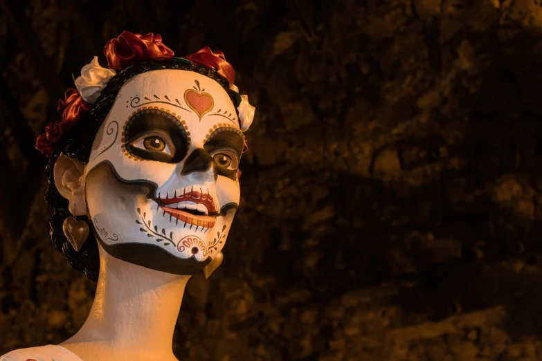 a woman with white and black make up wearing a rose headdress