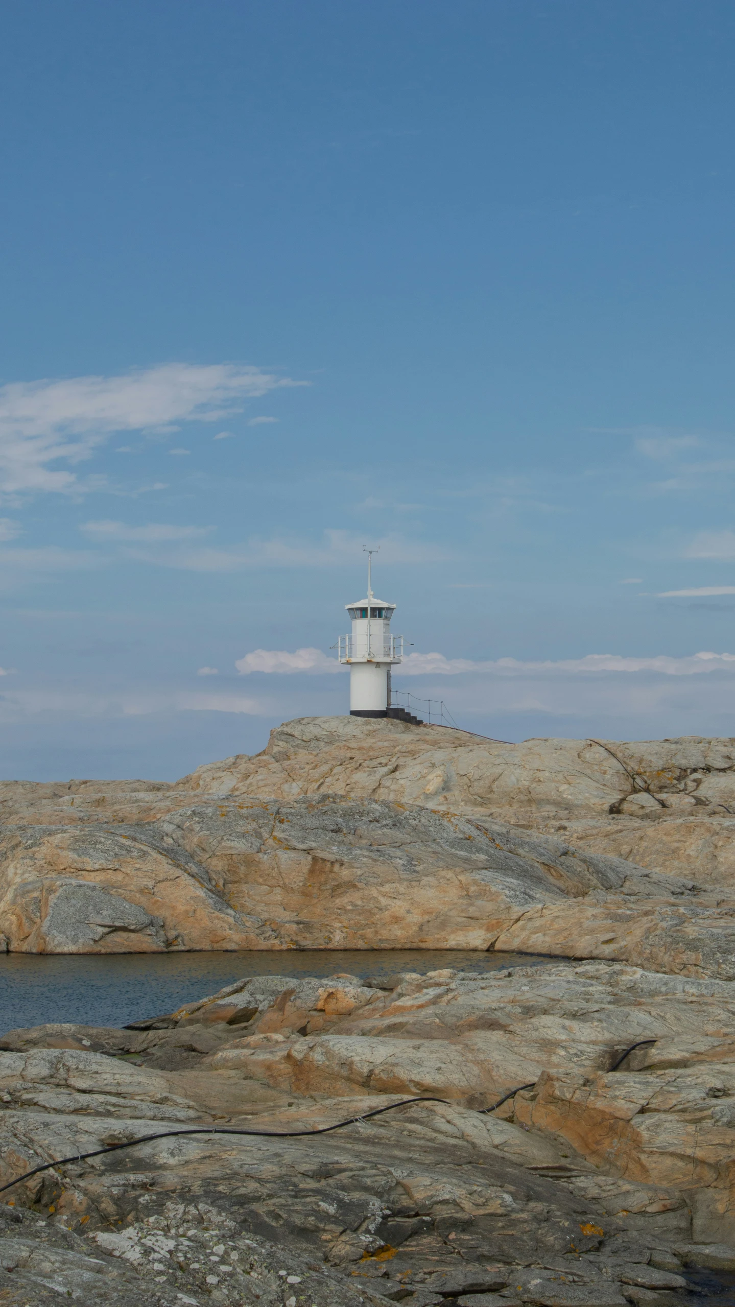 an image of a light house on the side of a cliff