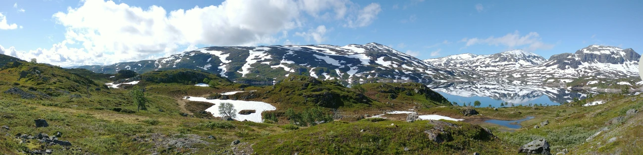 an aerial view shows a snow covered mountain and surrounding forest