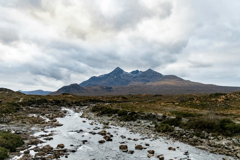 a stream runs through the ground in front of mountains