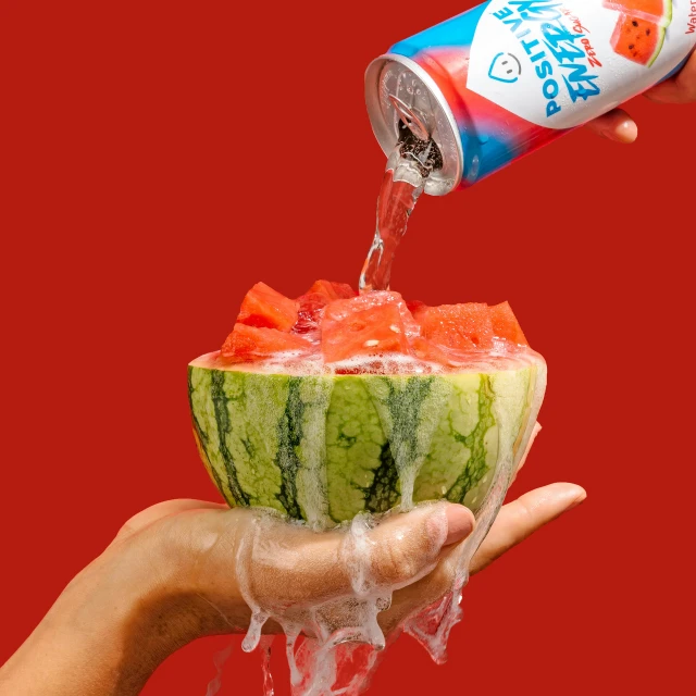 hand holding a canned watermelon and holding a can