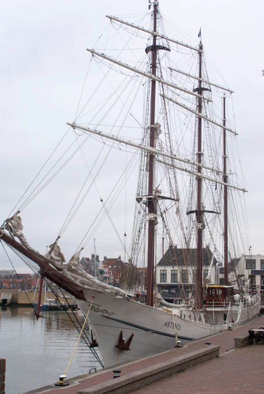 an old sailing vessel at the dock near the city