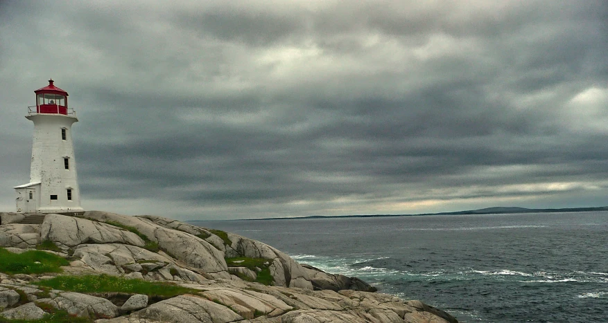 a lighthouse on top of a cliff next to the ocean