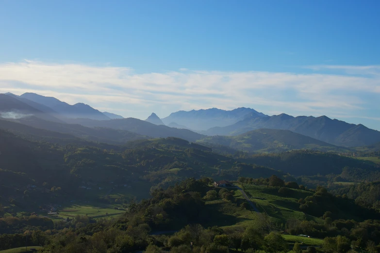 an aerial view of some mountains with trees in the foreground