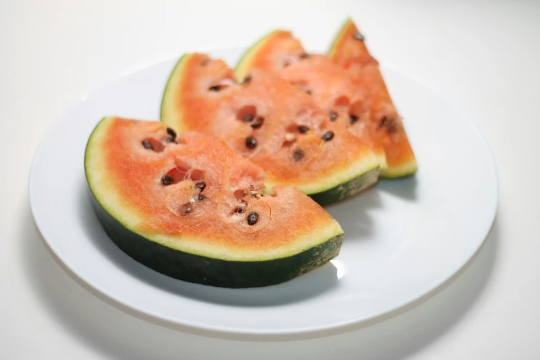 there are slices of a large watermelon on the white plate