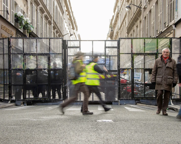 a couple of people standing near an open fence