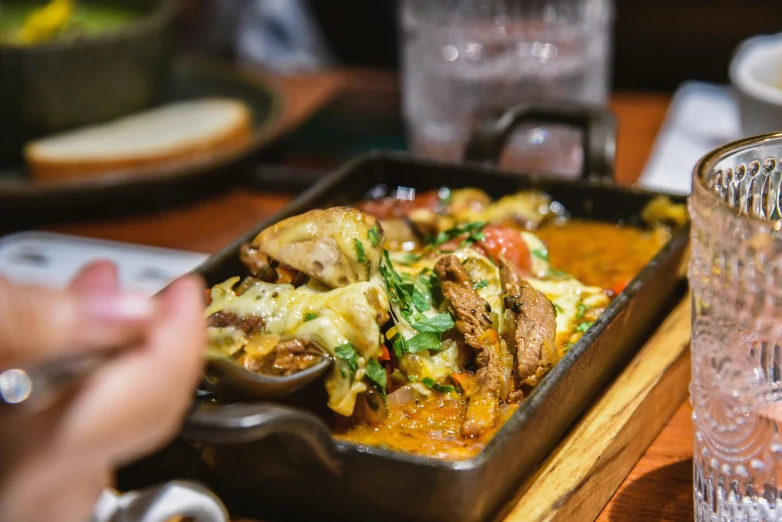 a tray with several different types of food and a person taking a po