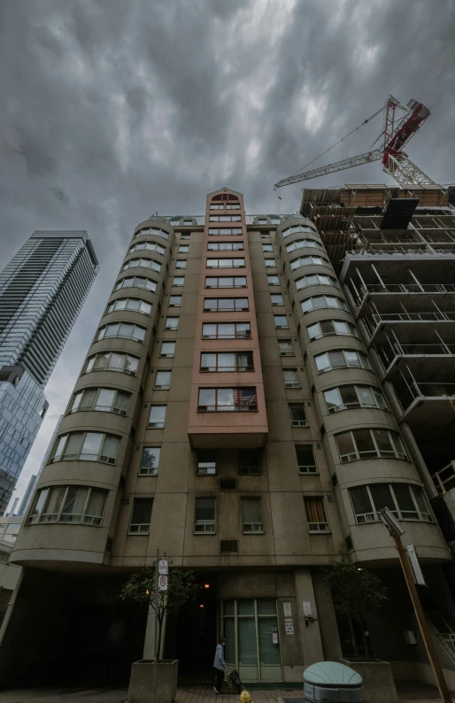 the tall building has many windows and a lot of cars parked on it