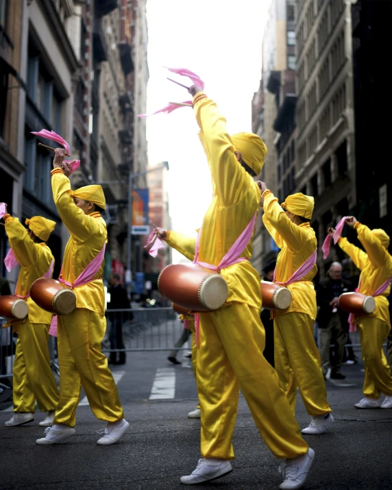 parade participants in yellow costumes with drums and sticks