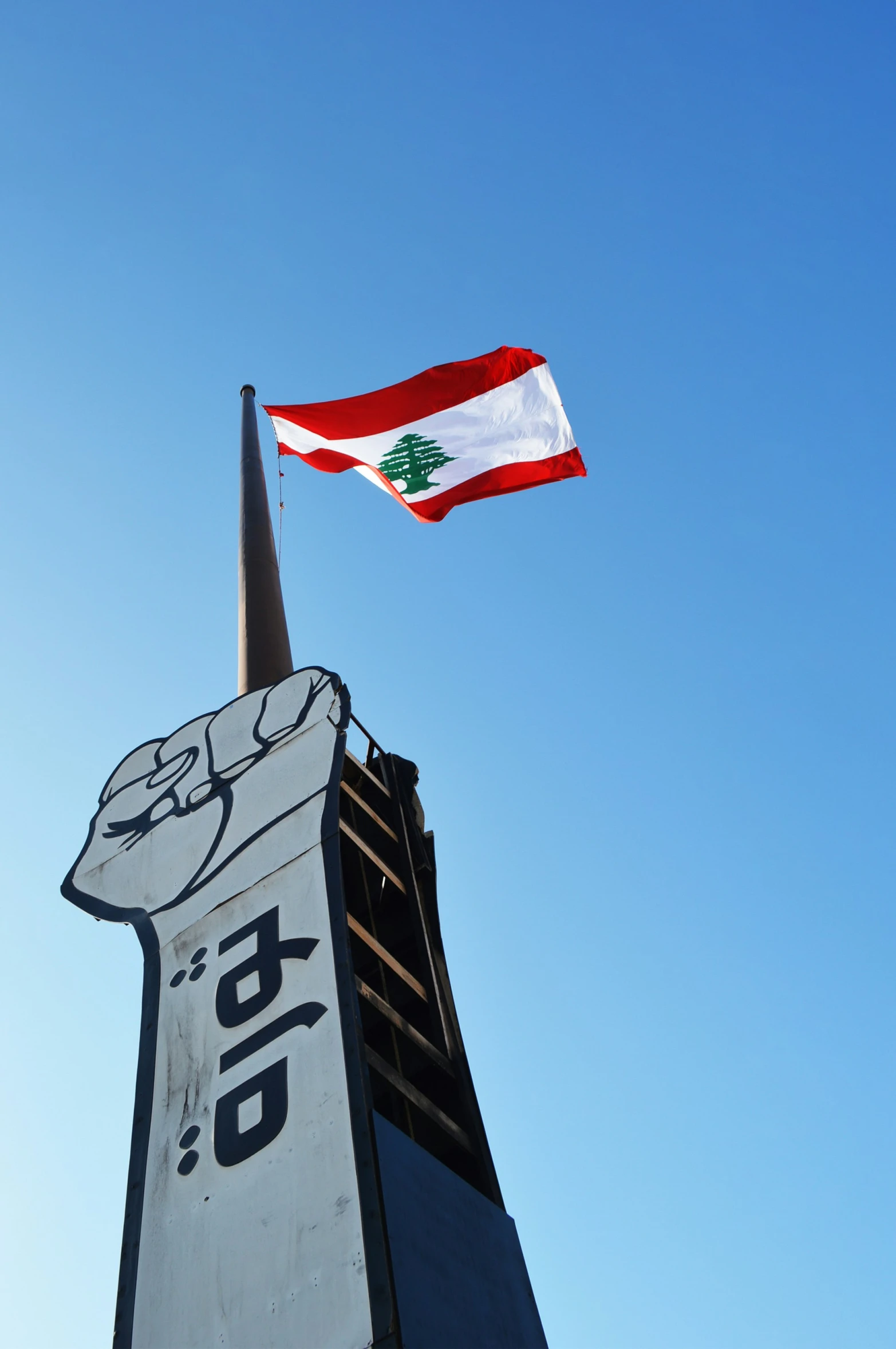 a flag flies next to the top of an architectural building