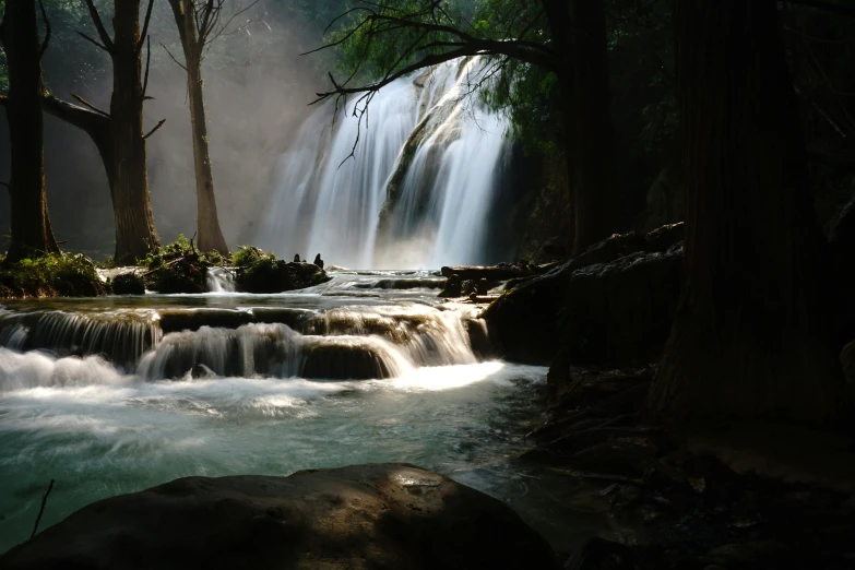 the waterfall is being viewed from behind rocks