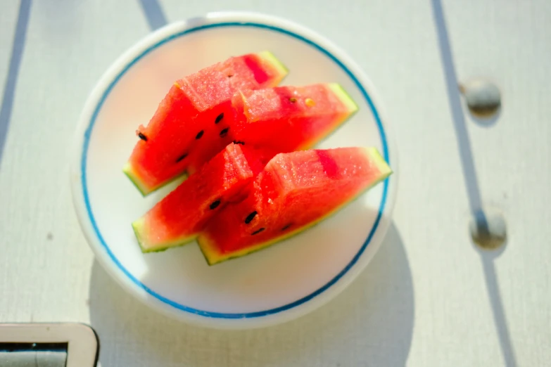 slices of watermelon sit on a white plate