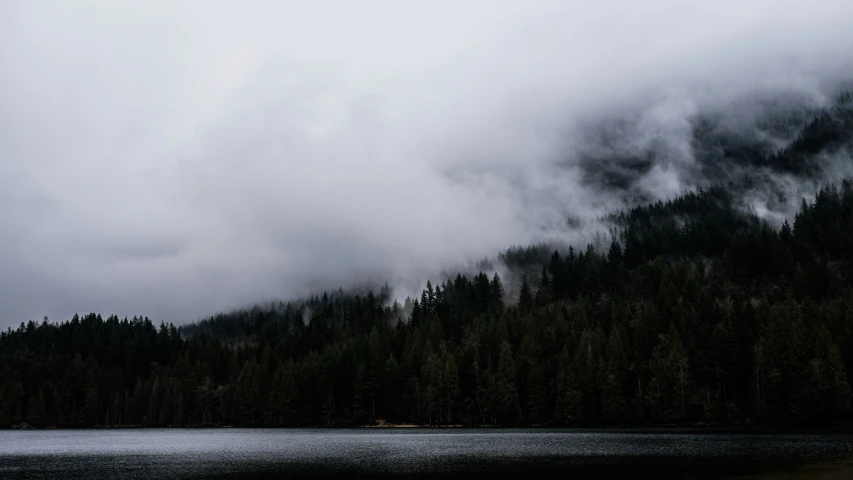 fog rolling in from the mountains and a boat on a body of water