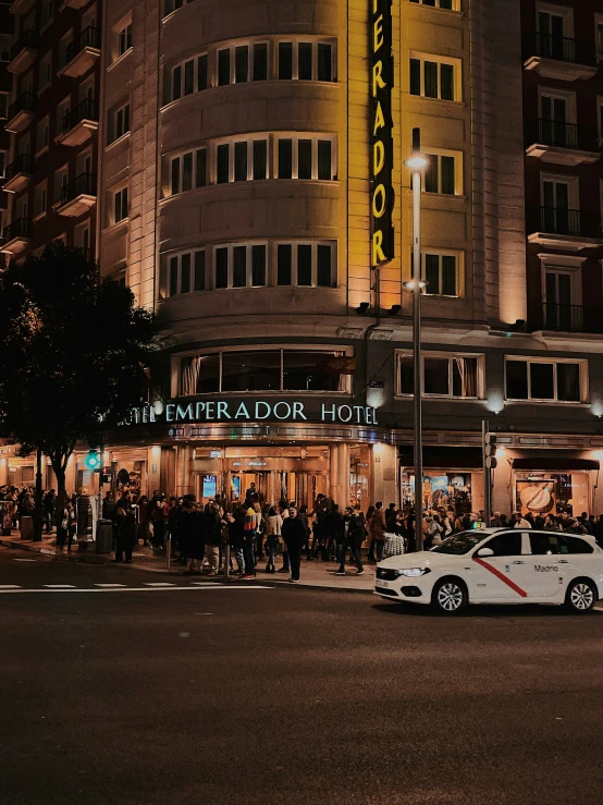 a city street with cars parked in front of a el at night