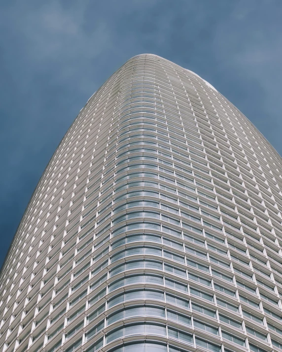 the very tall building is seen with a few clouds