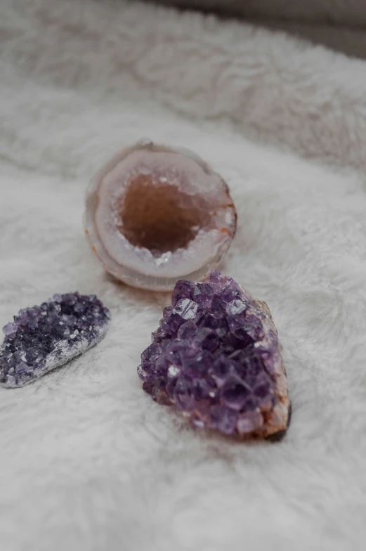 two aysts with purple crystals beside them on white fur