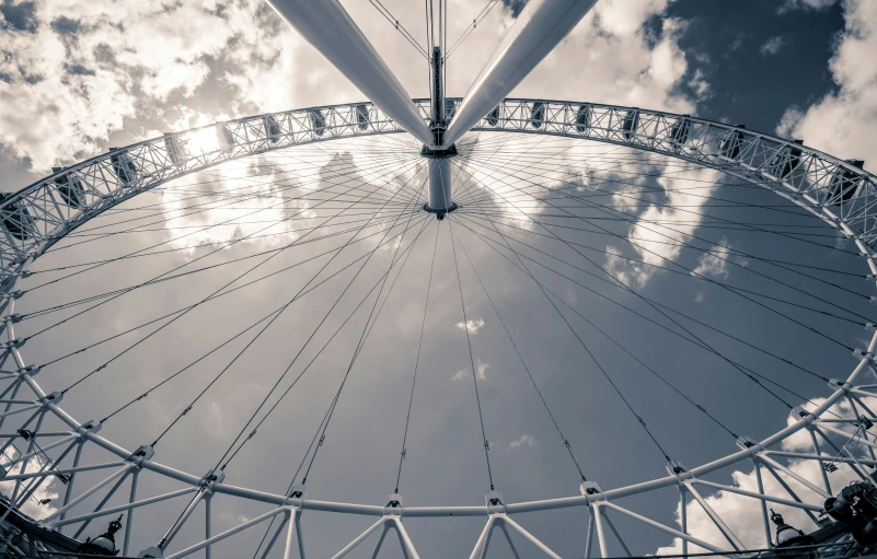 a big ferris wheel sits in front of some clouds