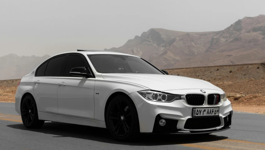 a white car on the road in a desert landscape