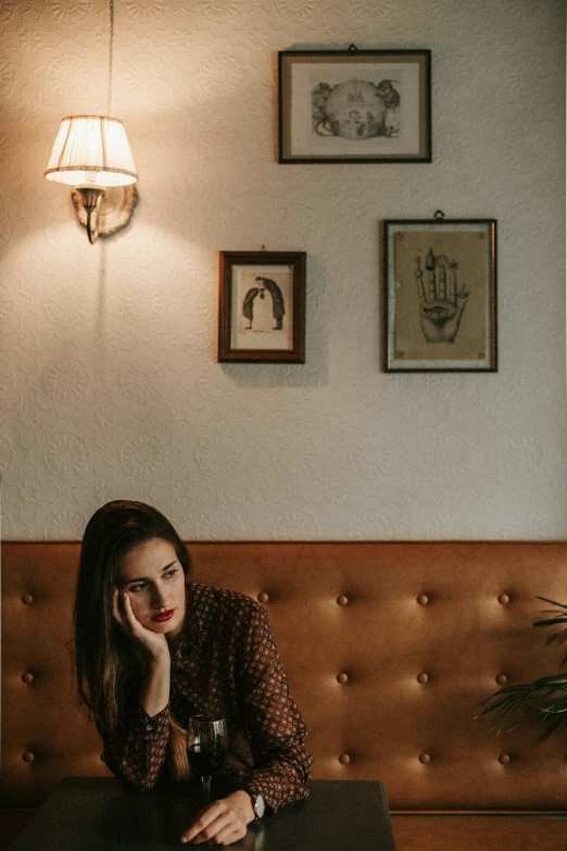 a beautiful woman sitting at a table in front of a wall