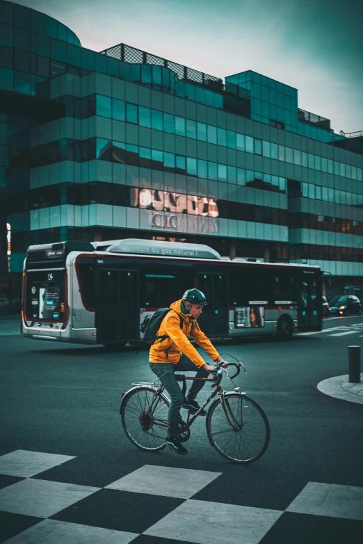 the man rides his bicycle on the sidewalk in front of the bus stop