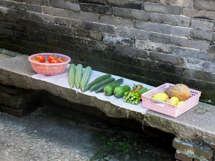 a stone bench topped with baskets filled with fruits