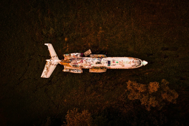 a white airplane painted with graffiti is shown from above