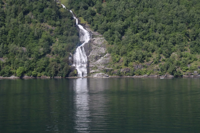 a man in a boat is near the waterfall