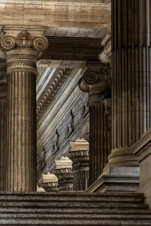 a tall building with pillars and a clock on the top