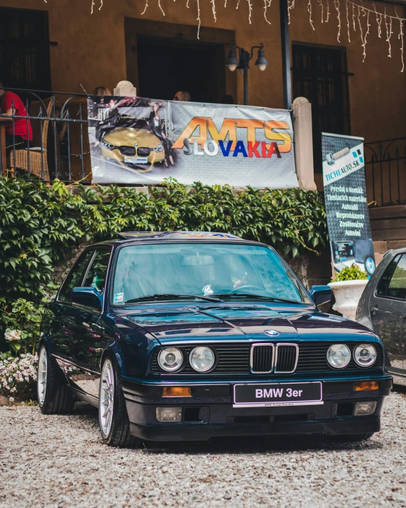 an automobile with the hood down on parked in front of a building