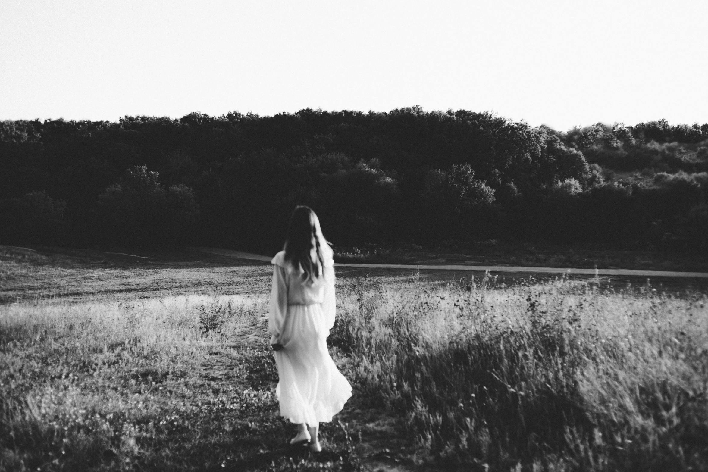 a person standing in the middle of a grassy field