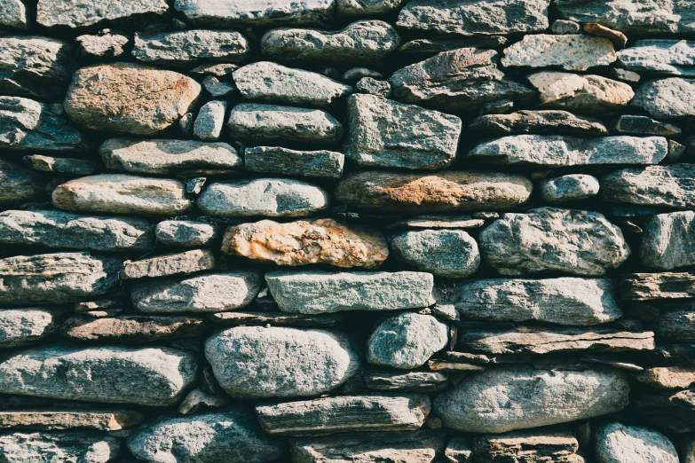 a stone wall with different colored rocks on top