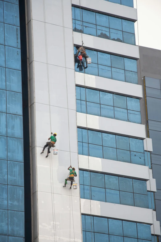 three men work on an outside area of a building