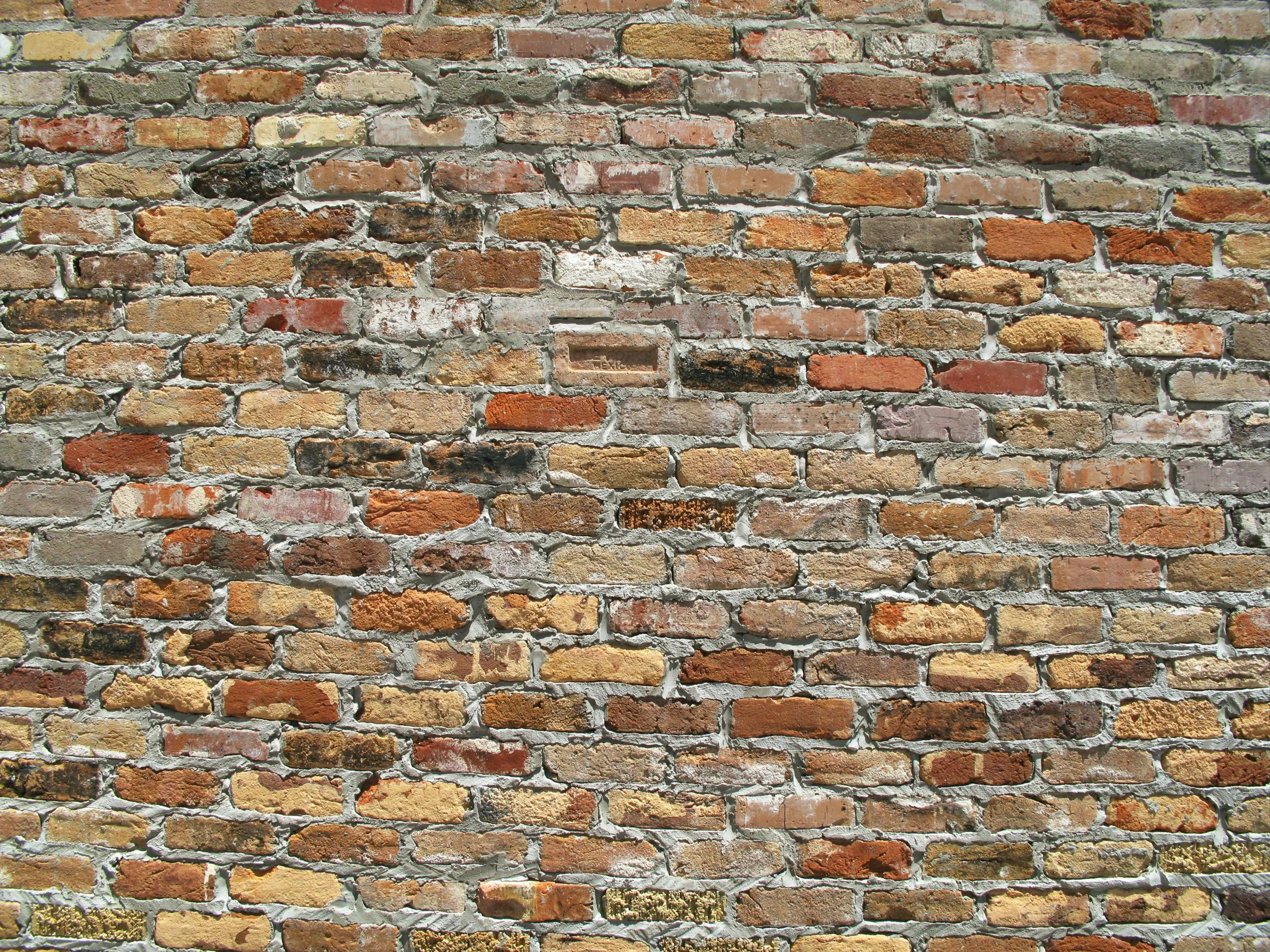 an old brick wall is painted yellow orange and red