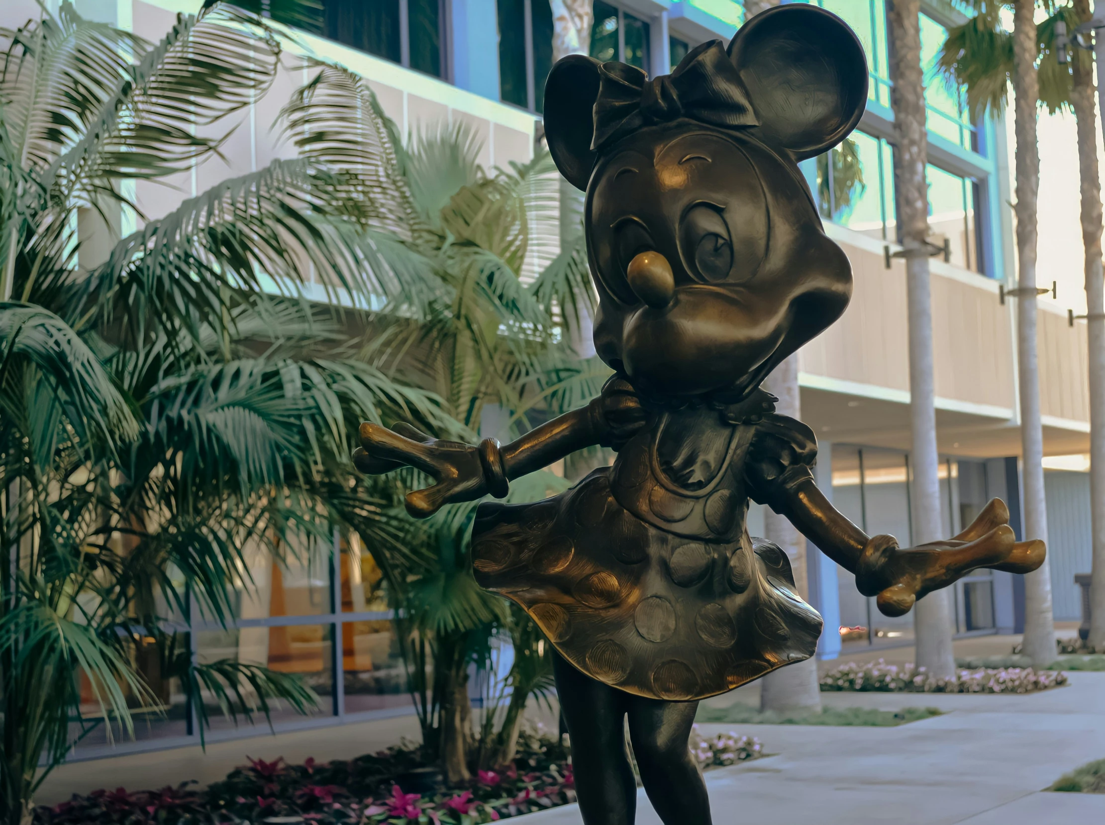 a statue of mickey mouse holding the arm of another person