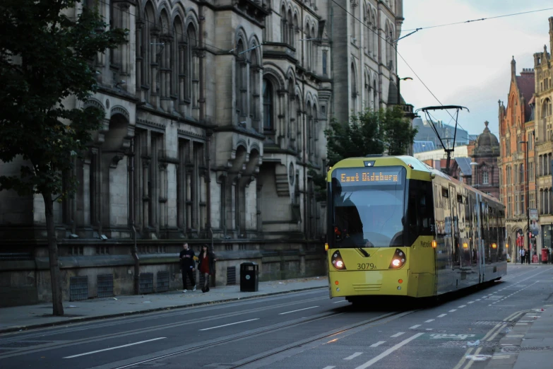 a yellow and white transit bus traveling down a street