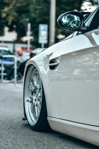 a close up of the wheels and front end of a white car
