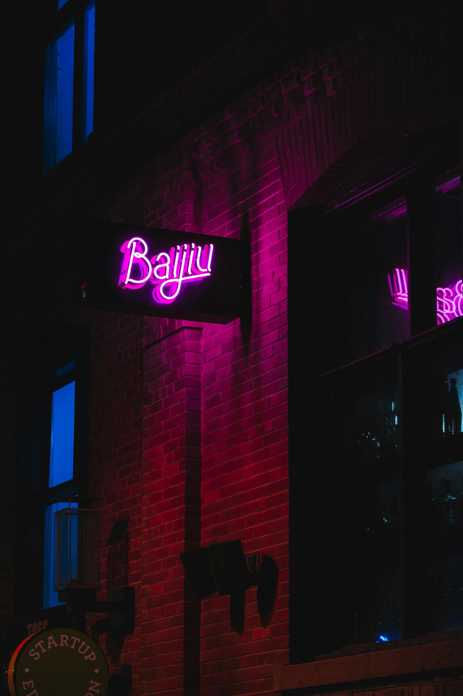 the neon signs of two buildings on each side of it