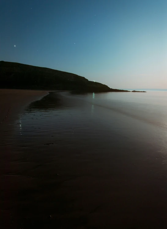 two surfers walking on beach at sunset