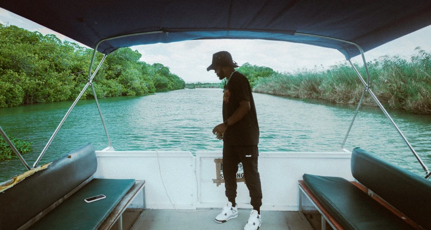 person standing on back of boat watching another