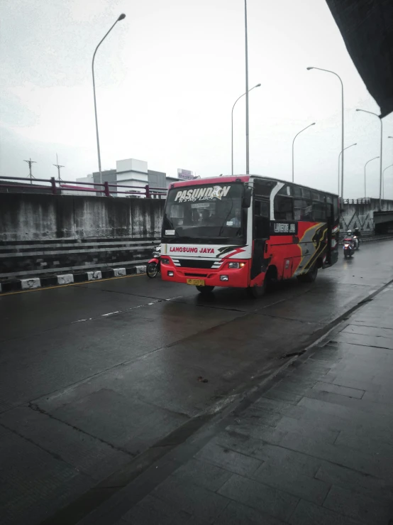 a city bus riding down a rainy street