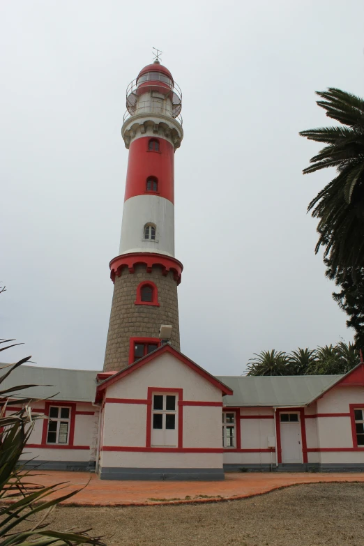 the light house is very tall and has red trim