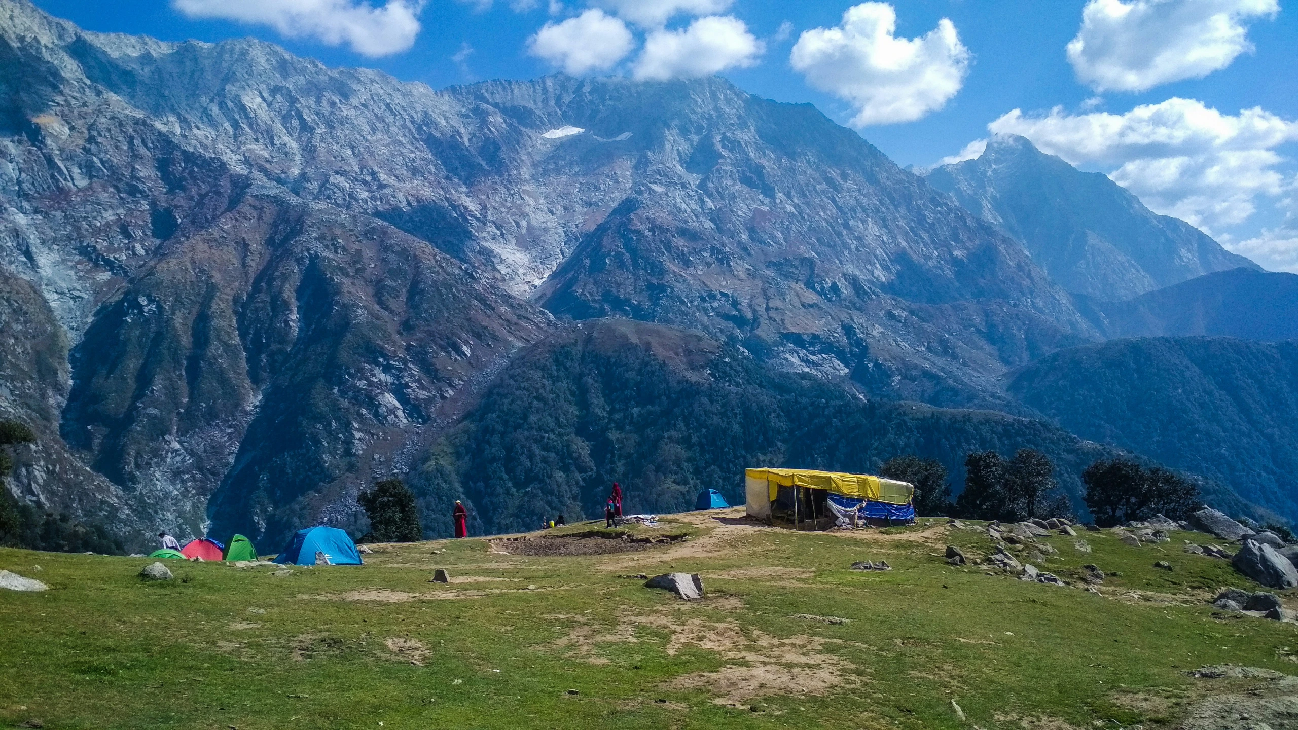 tent on a hillside with mountains in the background