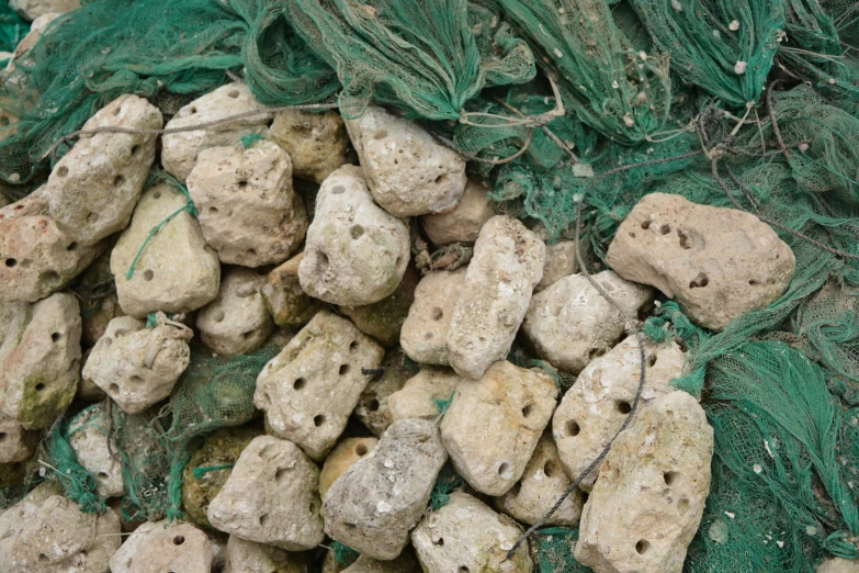 rocks are piled up on top of some mesh