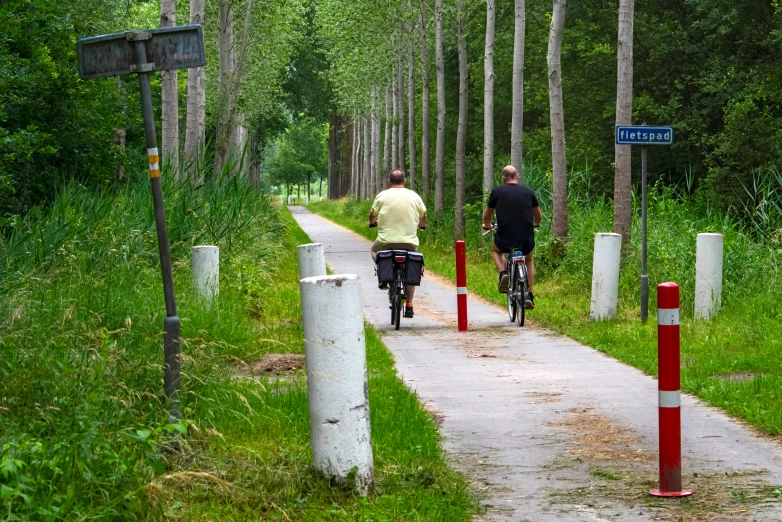 a man and a woman riding bicycles down the road