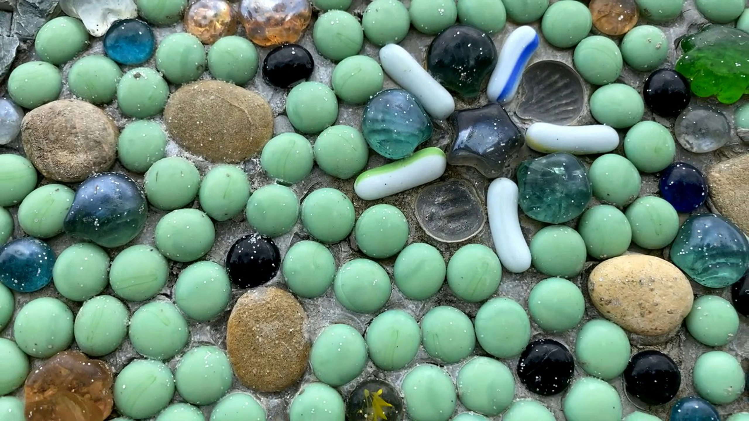 green and blue beads sitting on top of one another