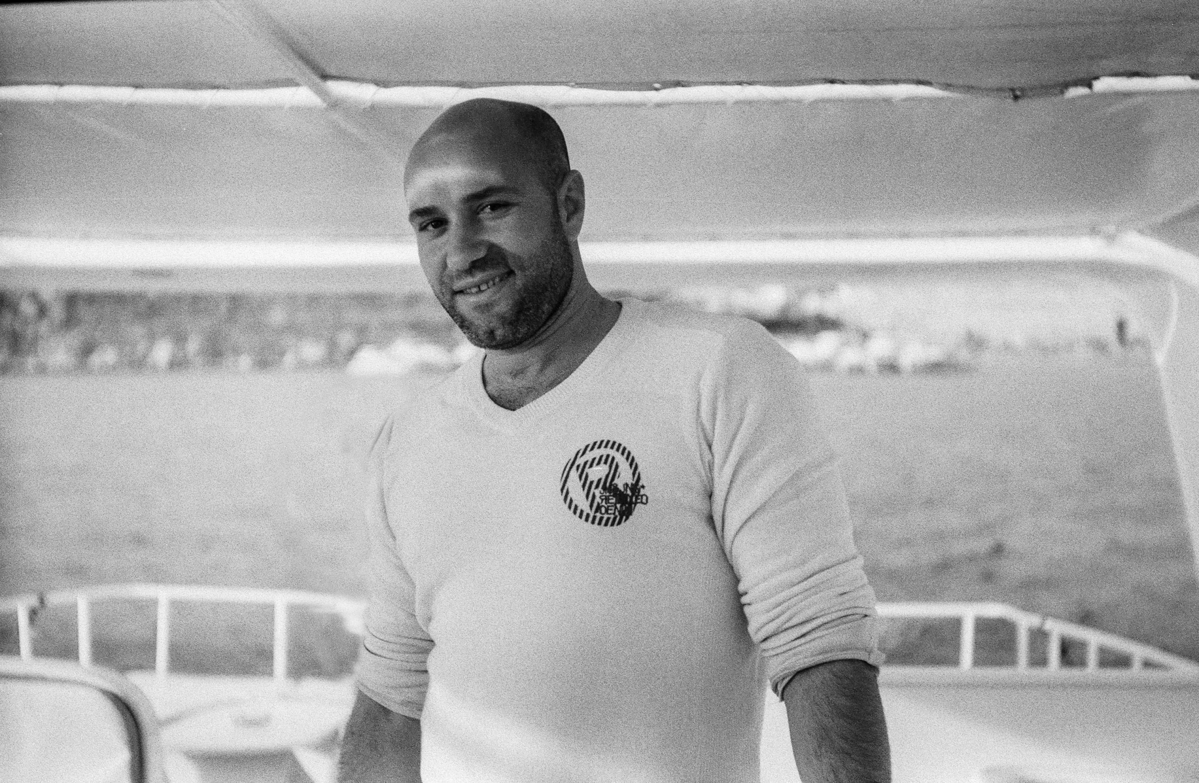 a man standing in front of a pool in a white shirt