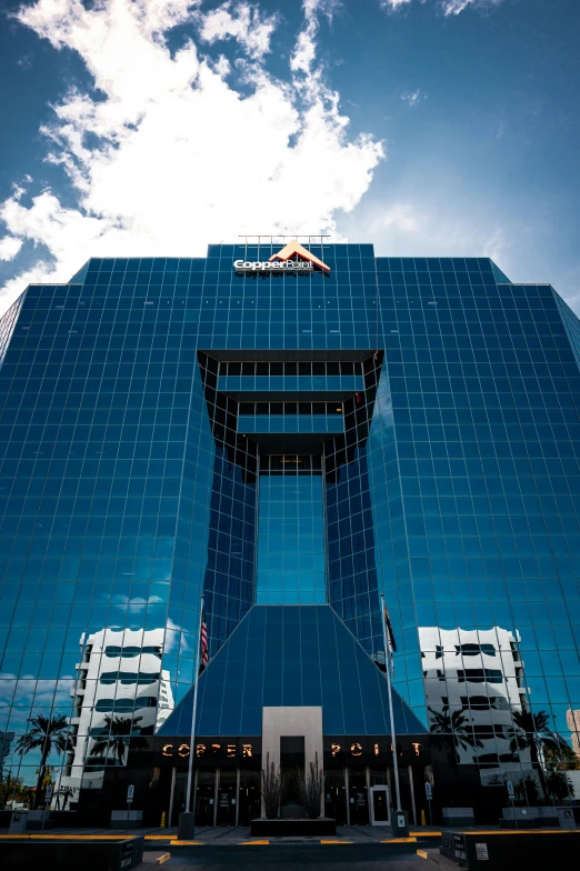 a large glass building with an airplane flying overhead